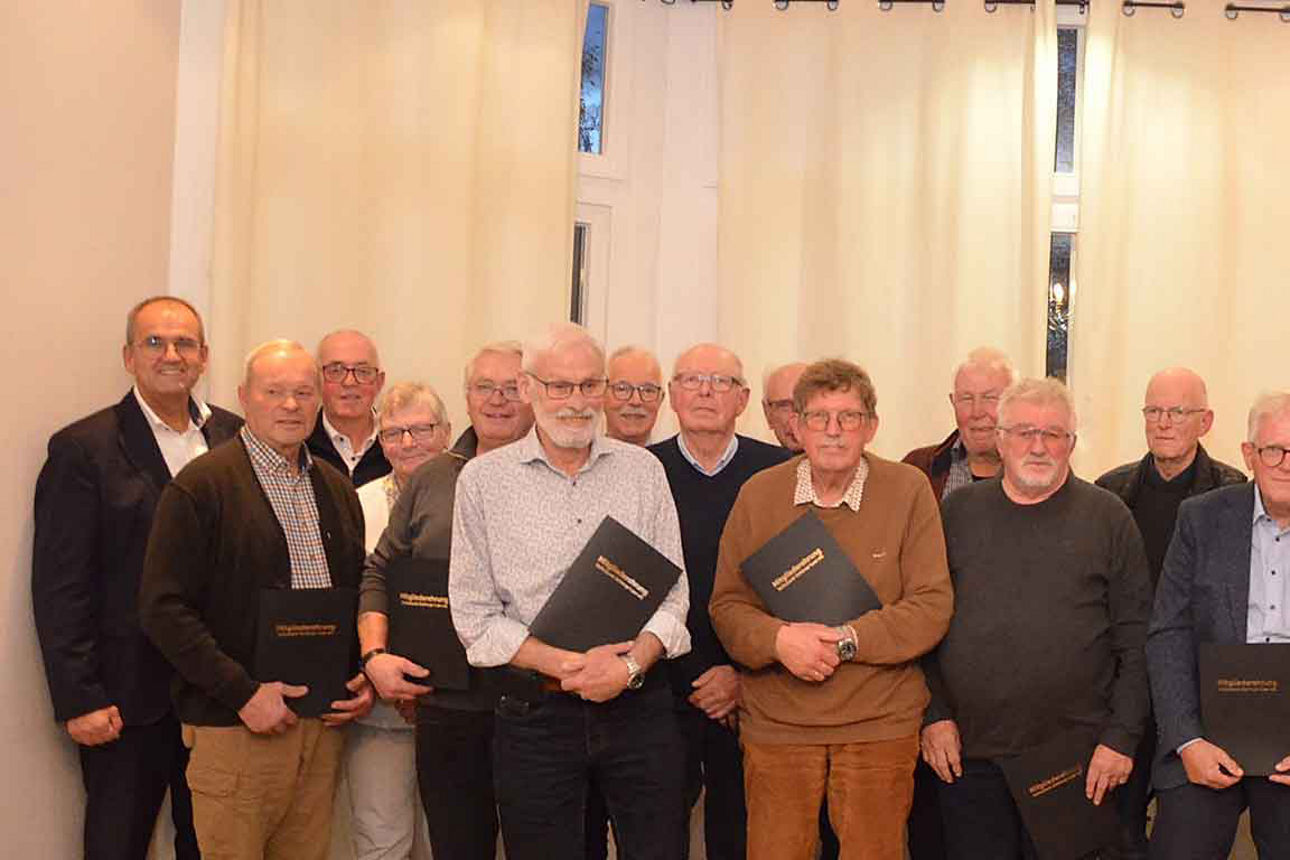 „Gruppe älterer Menschen bei einer Ehrungsveranstaltung – alle lächeln und halten Urkunden in der Hand.“