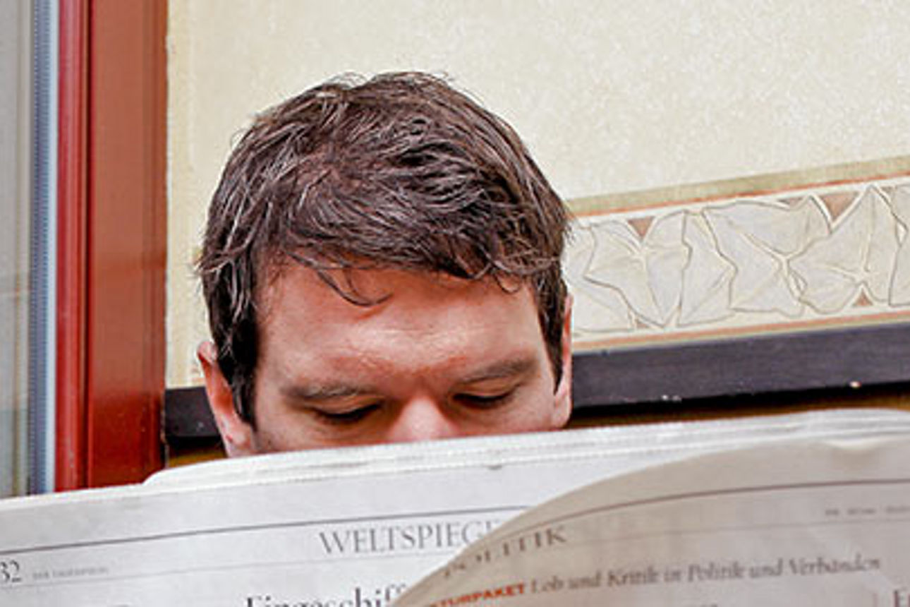 Mann mit einer Zeitung in der Hand