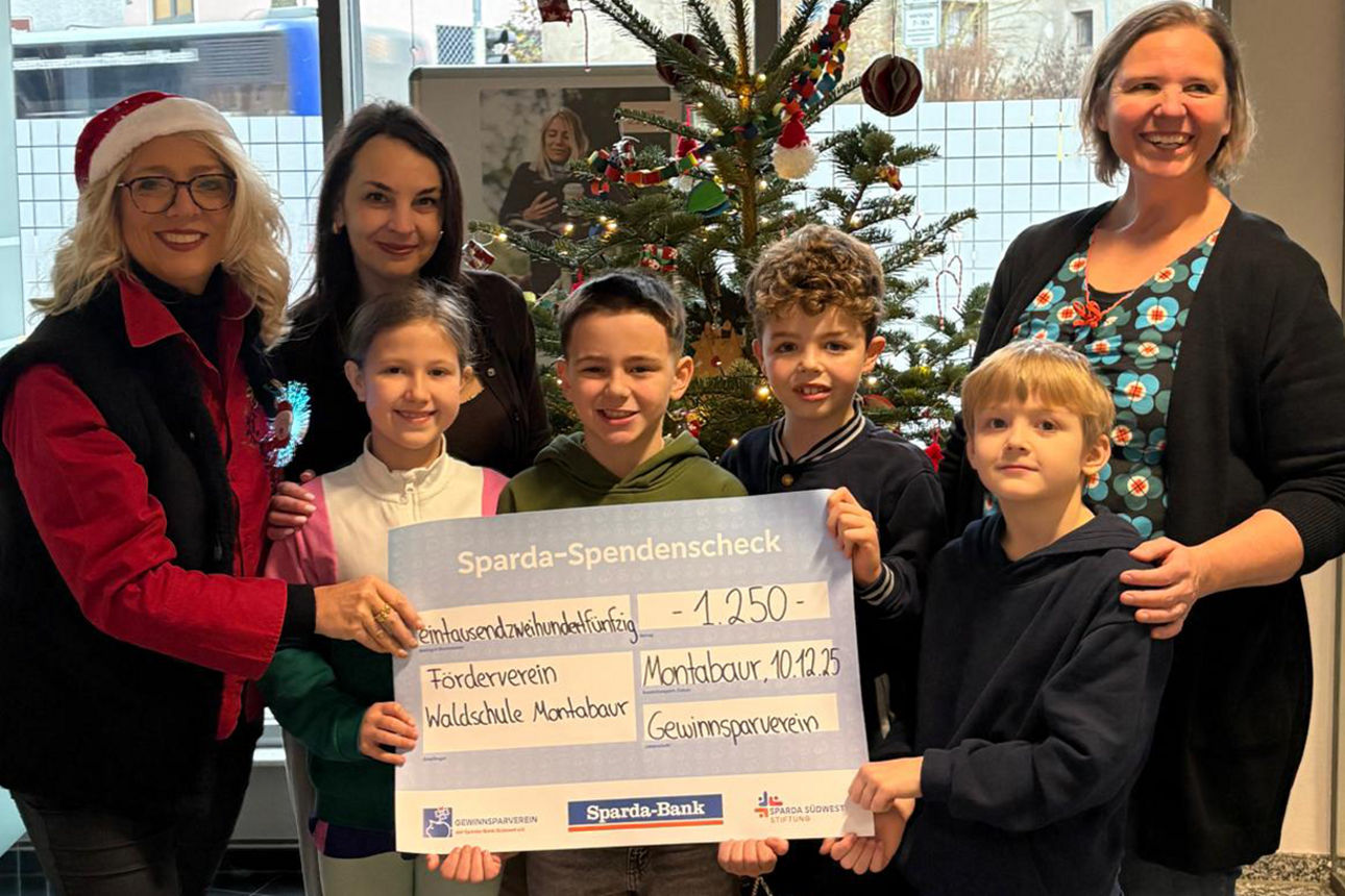 Kinder und Frauen mit Spendencheck und Weihnachtsbaum