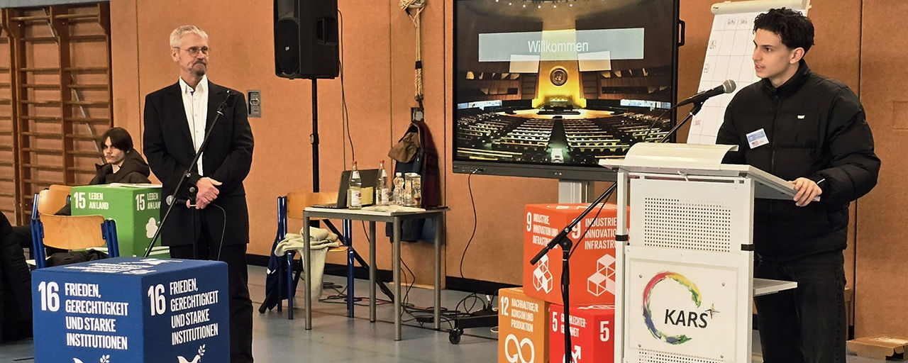 Mann der auf Klimakonferenz in der Schule eine Rede hält