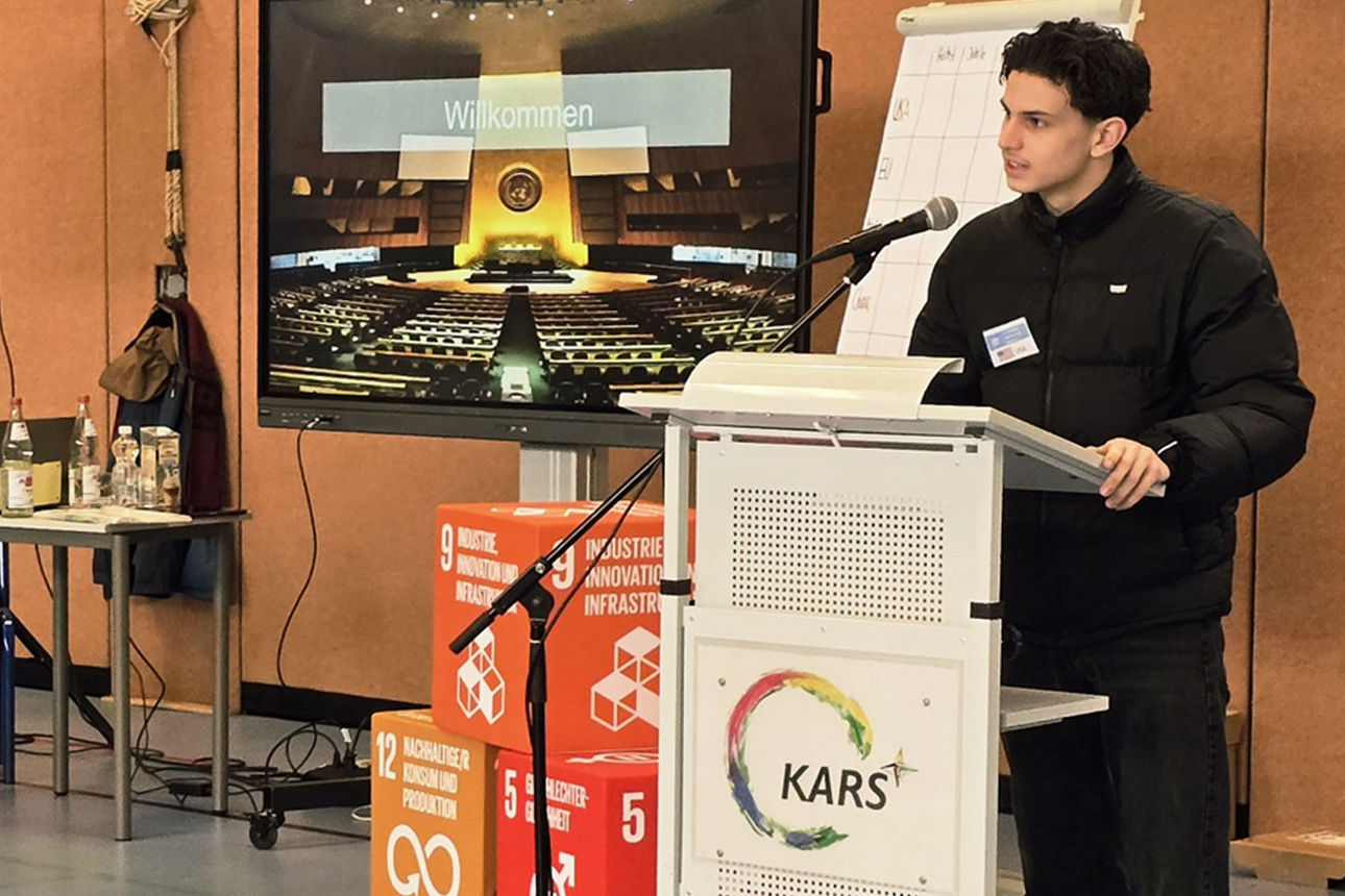 Mann der auf Klimakonferenz in der Schule eine Rede hält