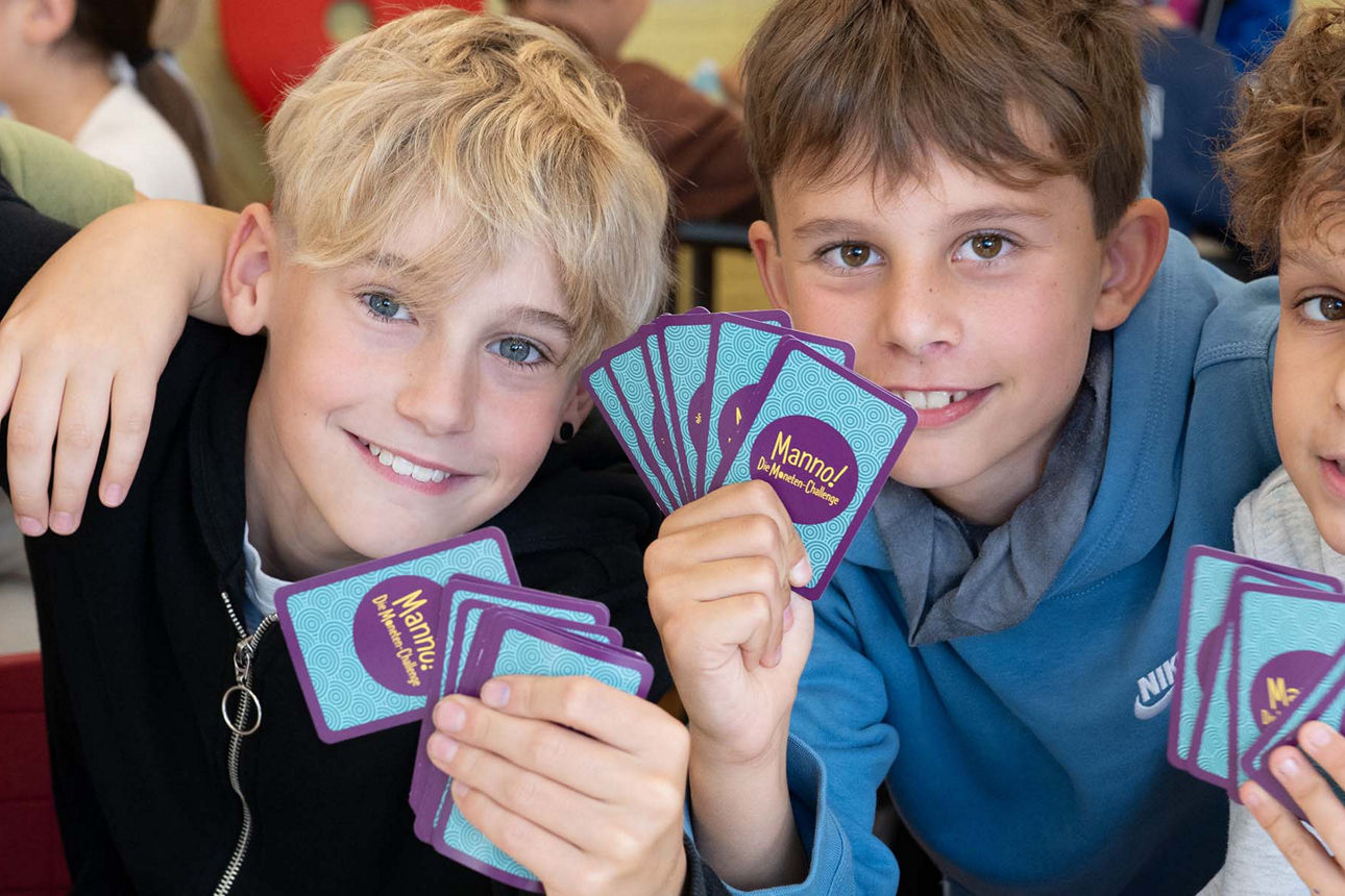 Kinder des Warndt-Gymnasiums mit Spielkarten in der Hand