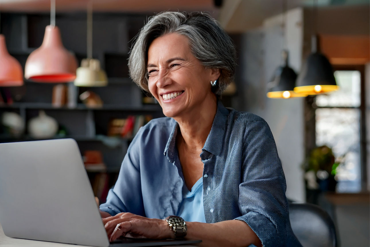 Lächelnde Frau sitzt am Laptop