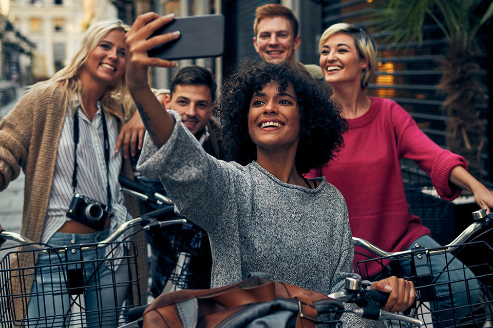Eine Gruppe junger Leute mit Fahrrädern macht ein Selfie