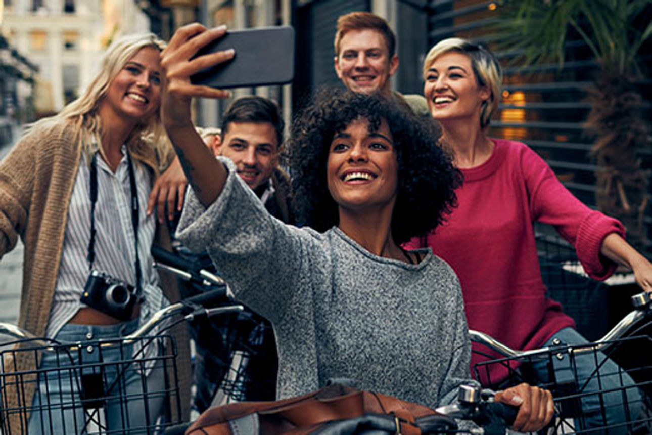 Eine Gruppe junger Leute mit Fahrrädern macht ein Selfie