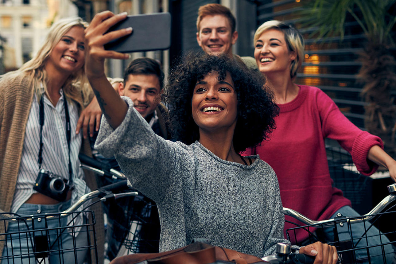 Eine Gruppe junger Leute mit Fahrrädern macht ein Selfie