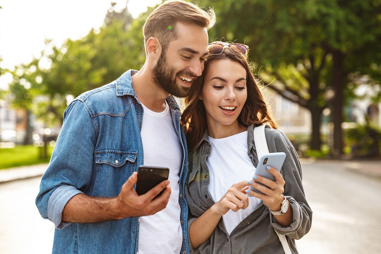Ein Mann und eine Frau schauen interessiert auf das Handy der Frau
