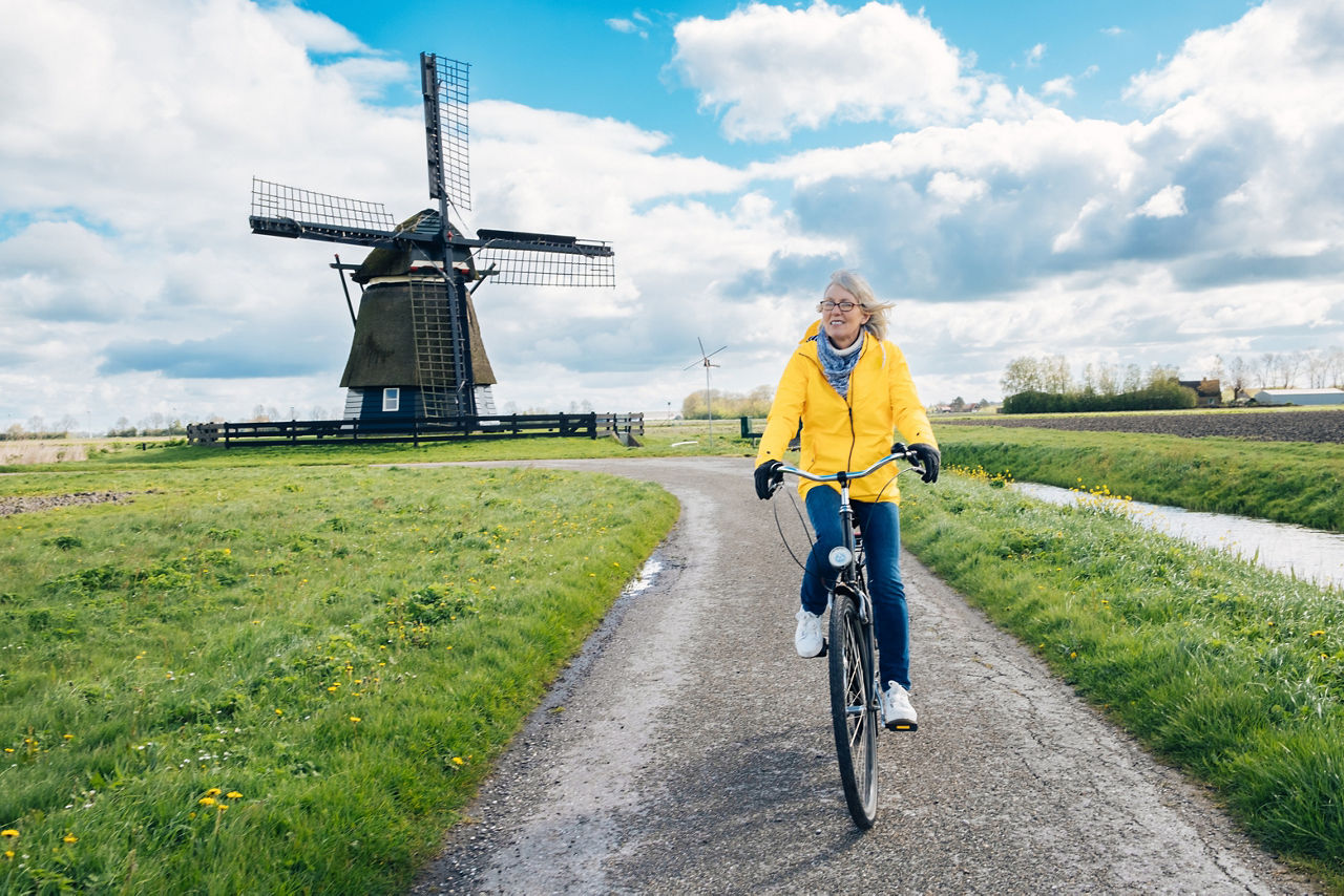 Frau auf einem Fahrrad vor einer Windmühle