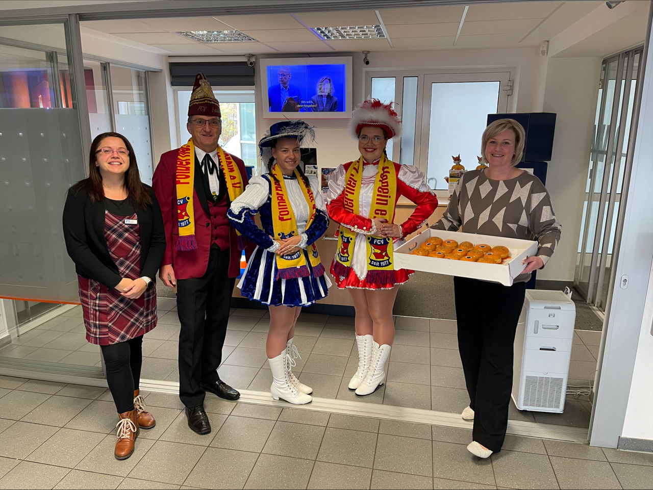 Eine Gruppe von Menschen in Faschingstracht lächeln vor der Kamera.
