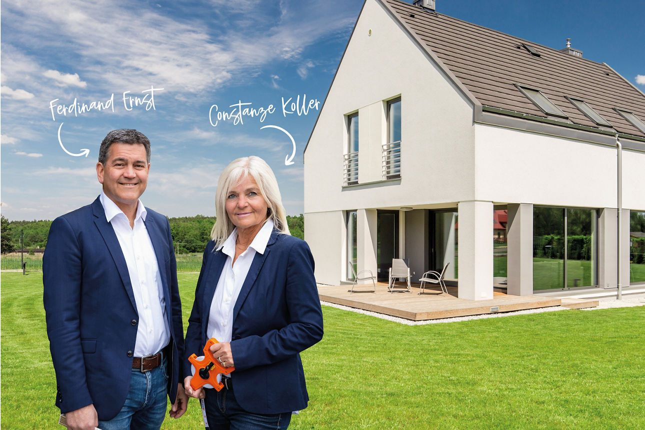 Zwei Personen vor modernem Einfamilienhaus auf Rasen, Portrait im Außenbereich