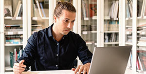 Mann sitzt in seinem Büro vor dem Laptop