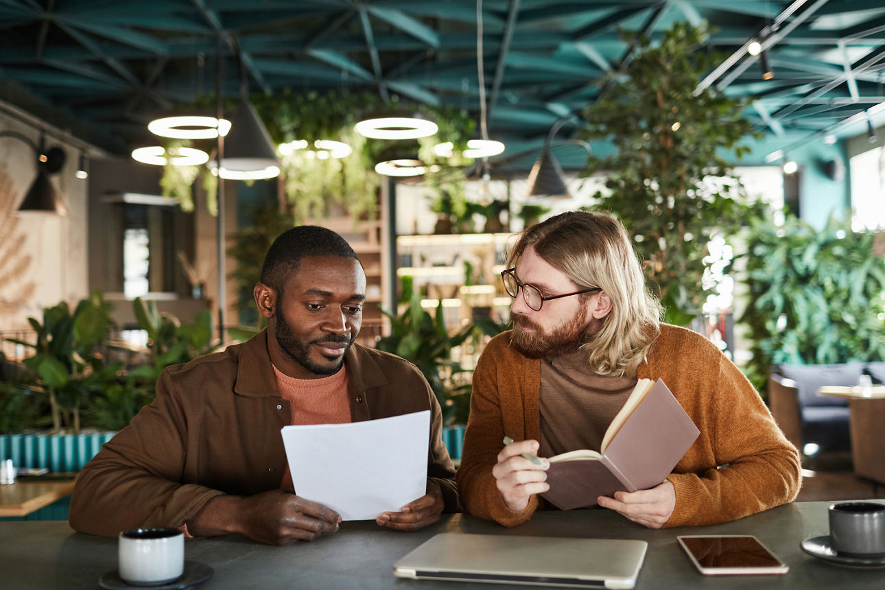 2 Männer arbeiten und schauen gemeinsam in Dokumente