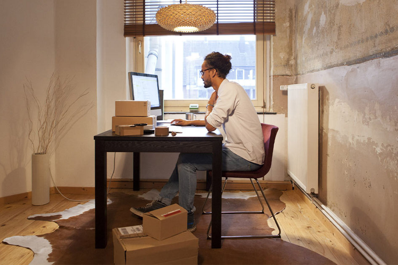 Ein Mann sitzt an seinem Rechner im Büro.