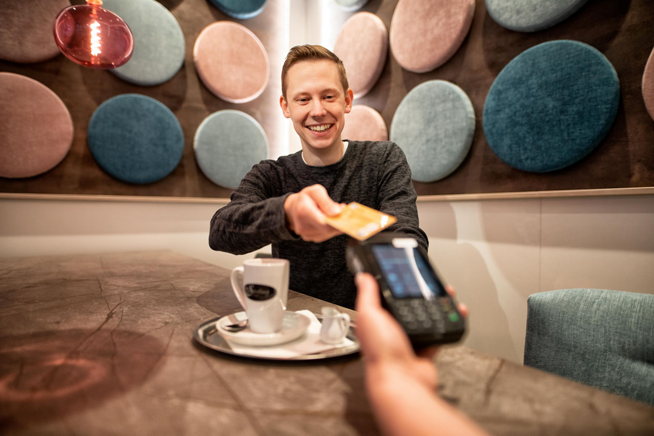 Mann bezahlt mit Karte in einem Café