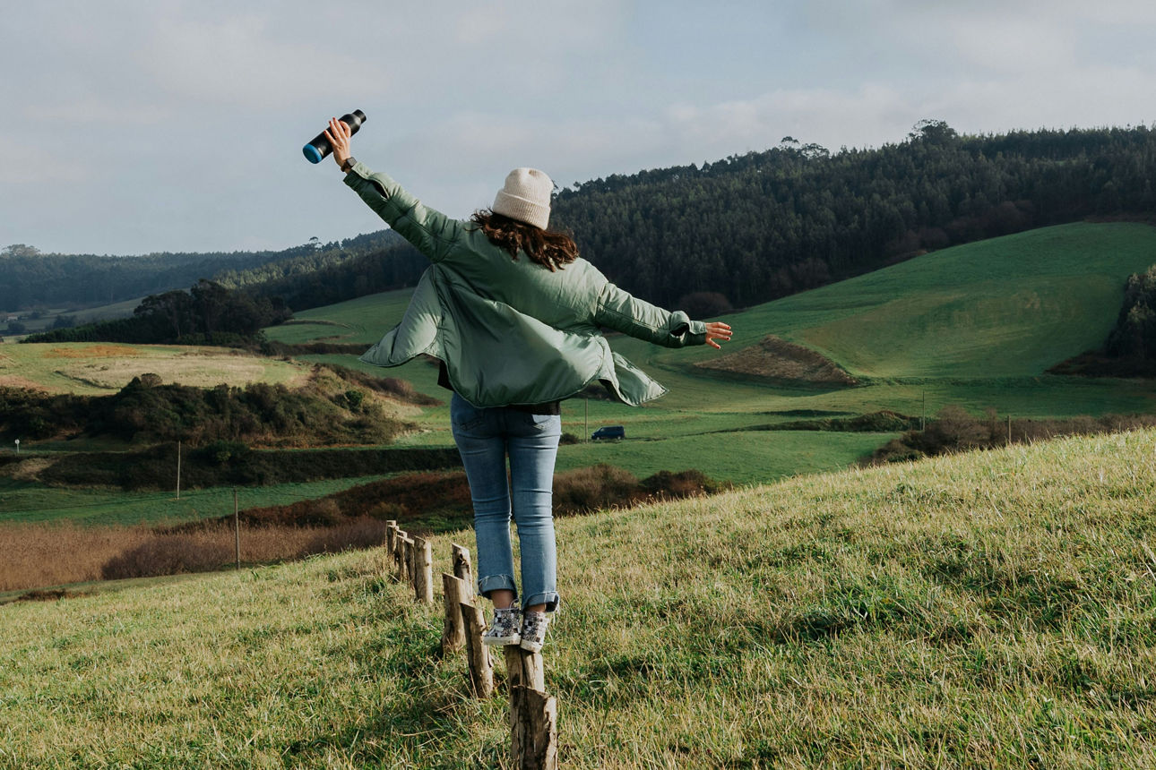 Frau balanciert auf Holzpfahl