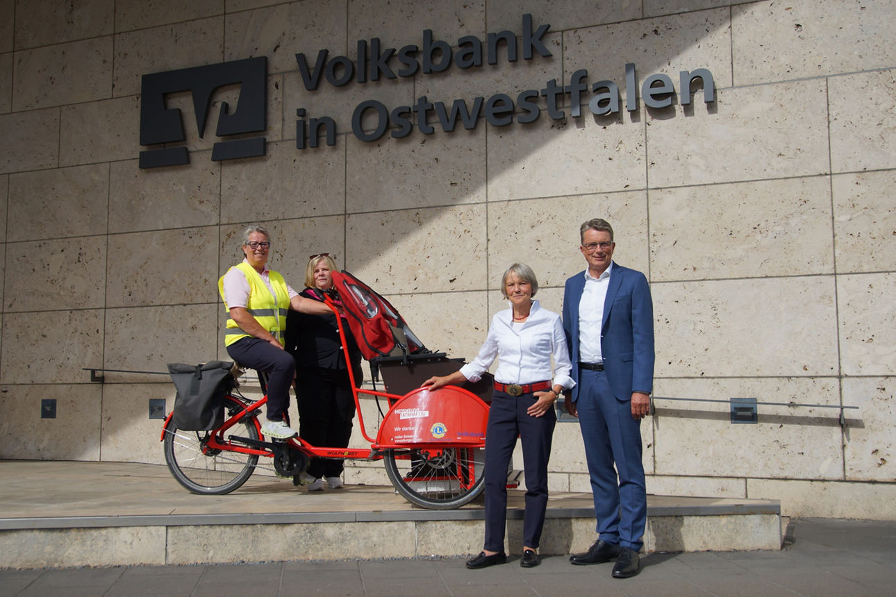 Doris Sonntag, Silke Strier und Michael Deitert mit einer Rikscha vor dem Volksbank Regionalzentrum Bielefeld