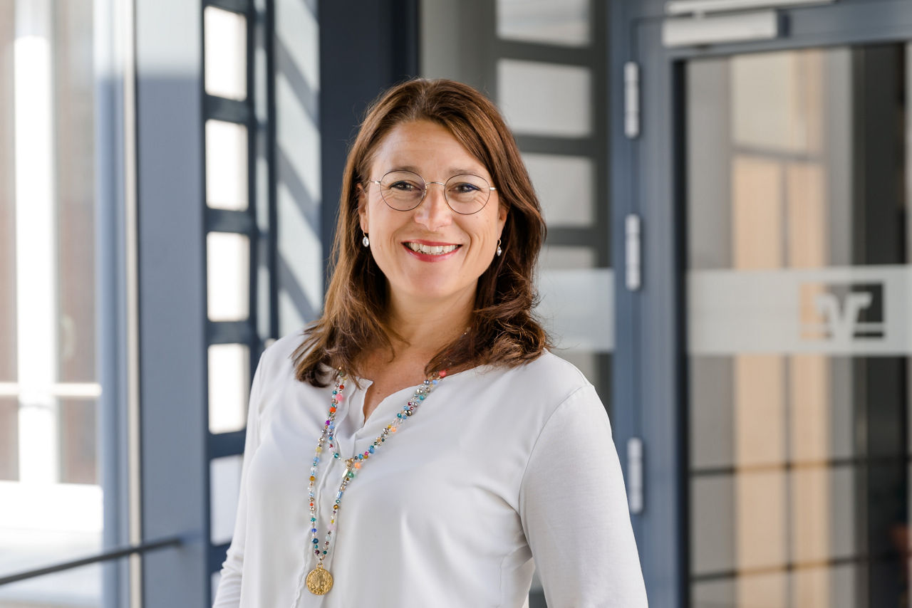 Portraitbild von Frau in weißer Bluse und dunklen Haaren.