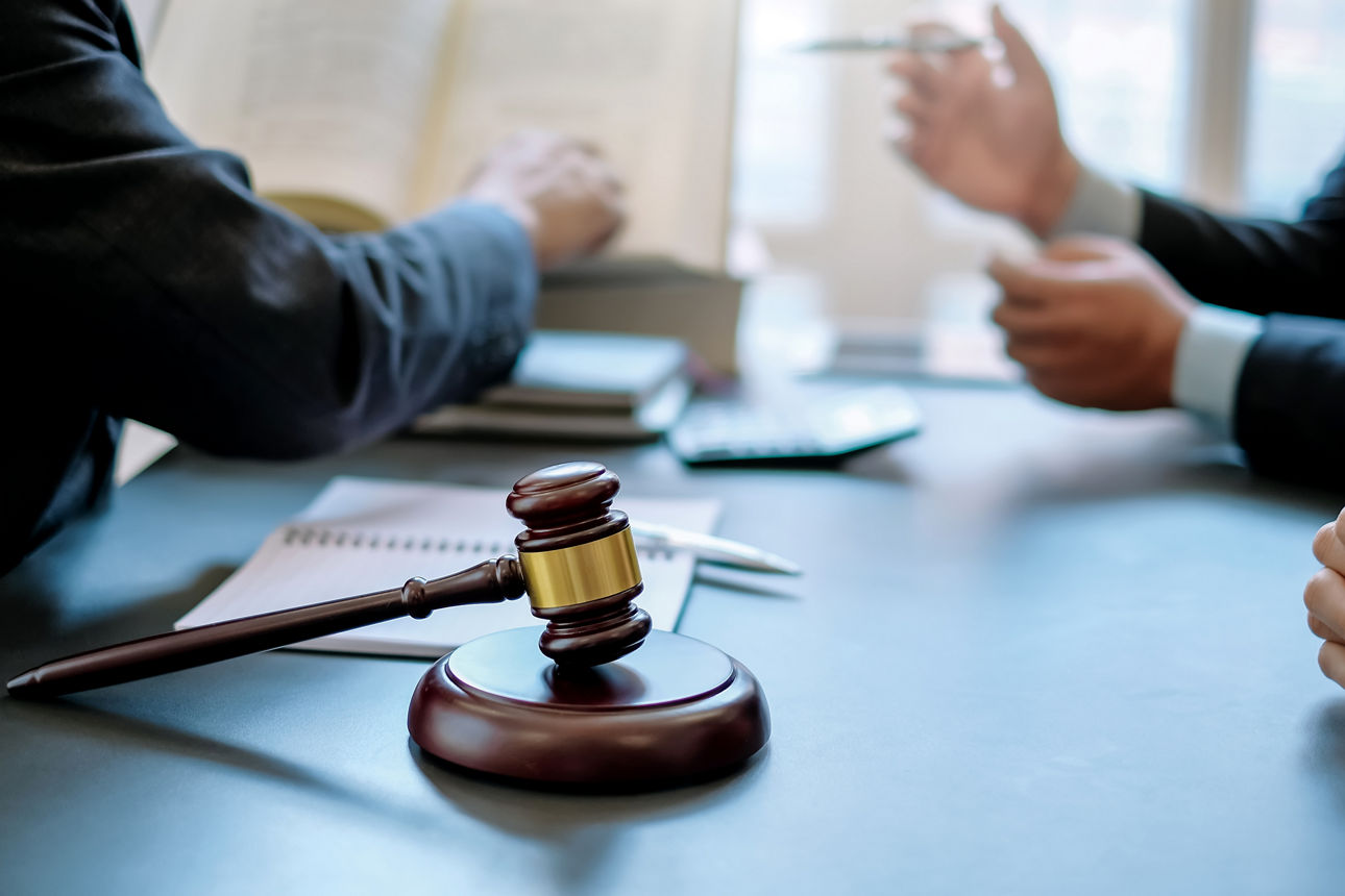 Drei Rechtsanwälte sitzen am Tisch und besprechen die Vorteile einer Rechtschutzversicherung