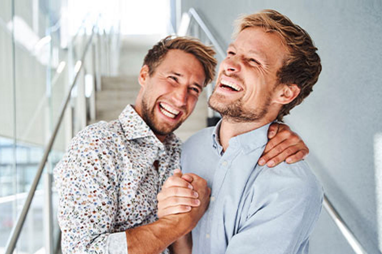 Zwei Männer, die sich lachend in den Armen liegen