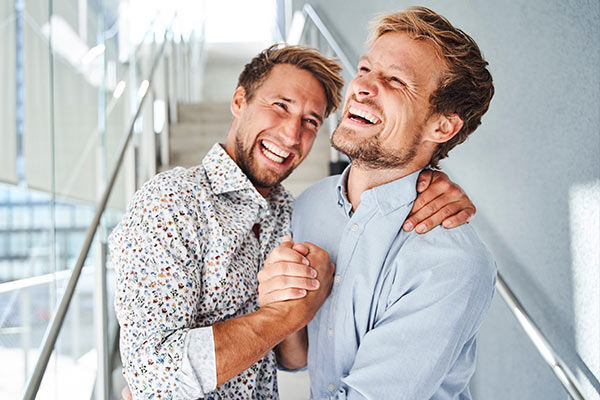 Zwei Männer, die sich lachend in den Armen liegen