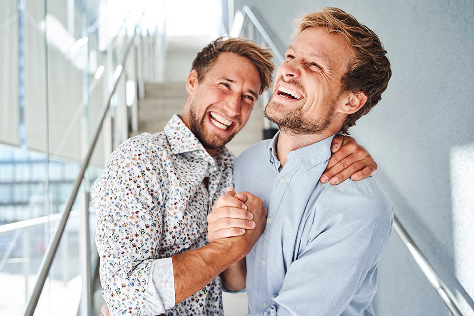 Zwei Männer, die sich lachend in den Armen liegen