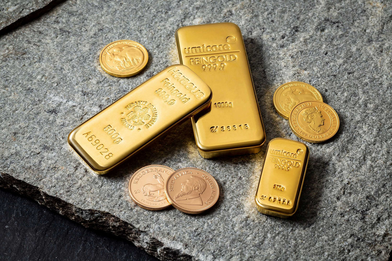 Goldbarren und Münzen liegen auf einem Tisch