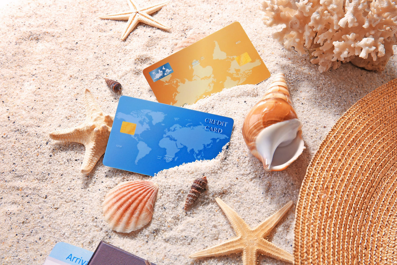 Kreditkarten und Muscheln im Sand