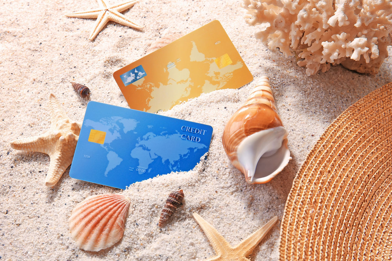 Kreditkarten und Muscheln im Sand