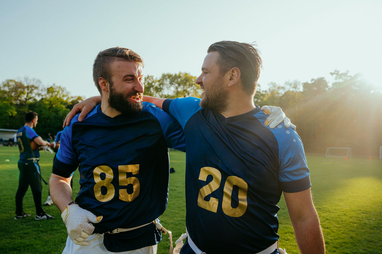 Menschenmenge im Freien mit Deutschlandfahnen, Deutschlandmützen und Deutschlandwimpeln bei einer Veranstaltung unter Bäumen.