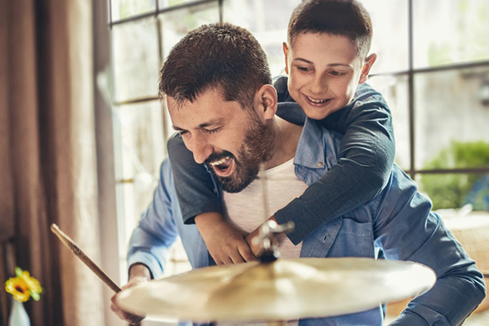 Vater und Sohn spielen zusammen Schlagzeug