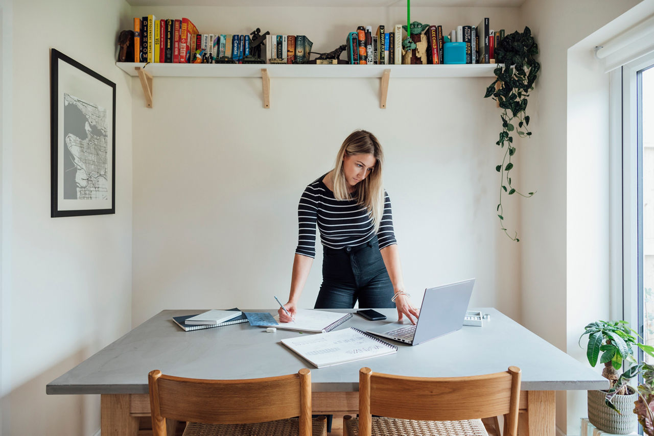 Junge Frau im Büro stehend vor Schreibtisch