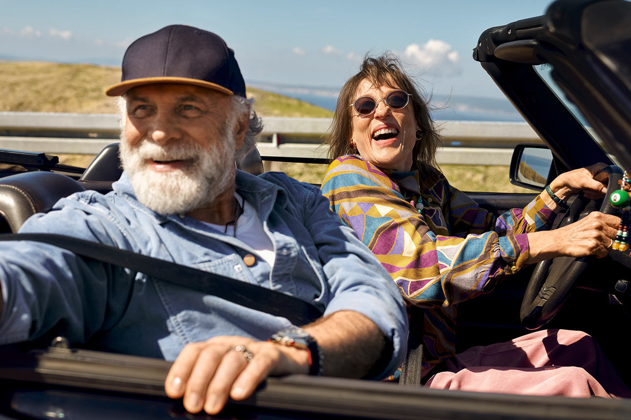 Lachendes Rentnerpaar in einem Cabrio
