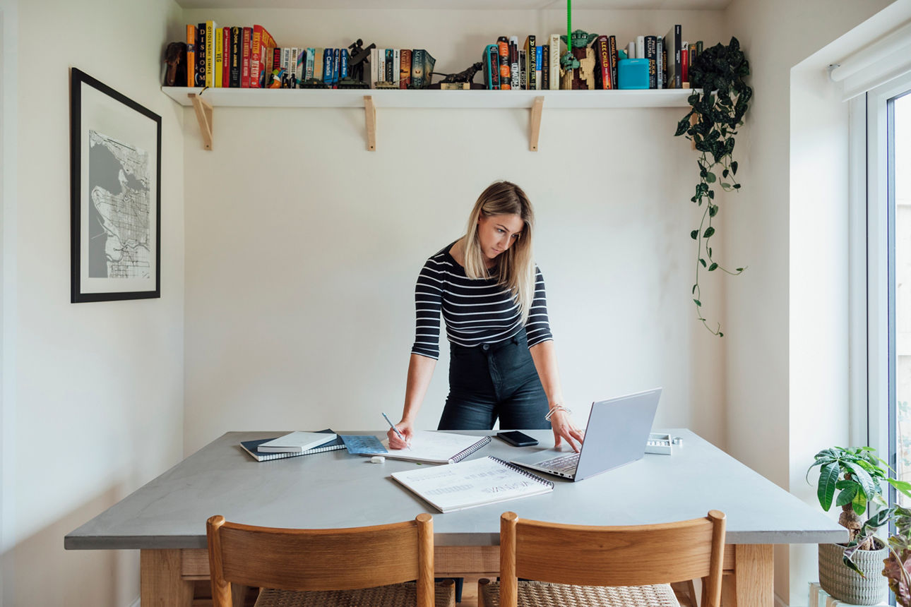 Junge Frau im Büro stehend vor Schreibtisch