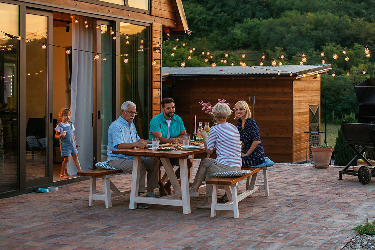Familie sitzt gemütlich auf der Terasse.