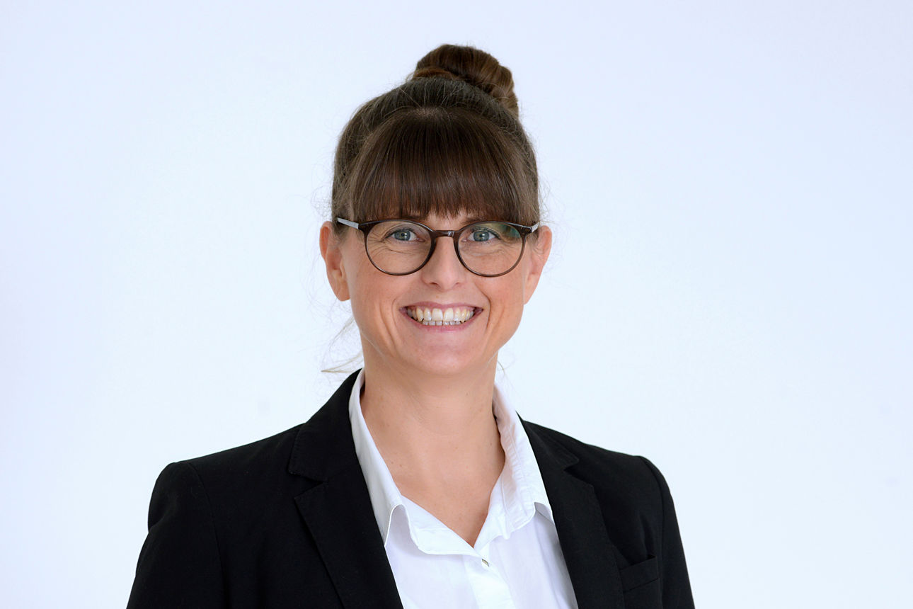 Geschäftskundenberaterin Sandra Gerke vor grauem Hintergrund