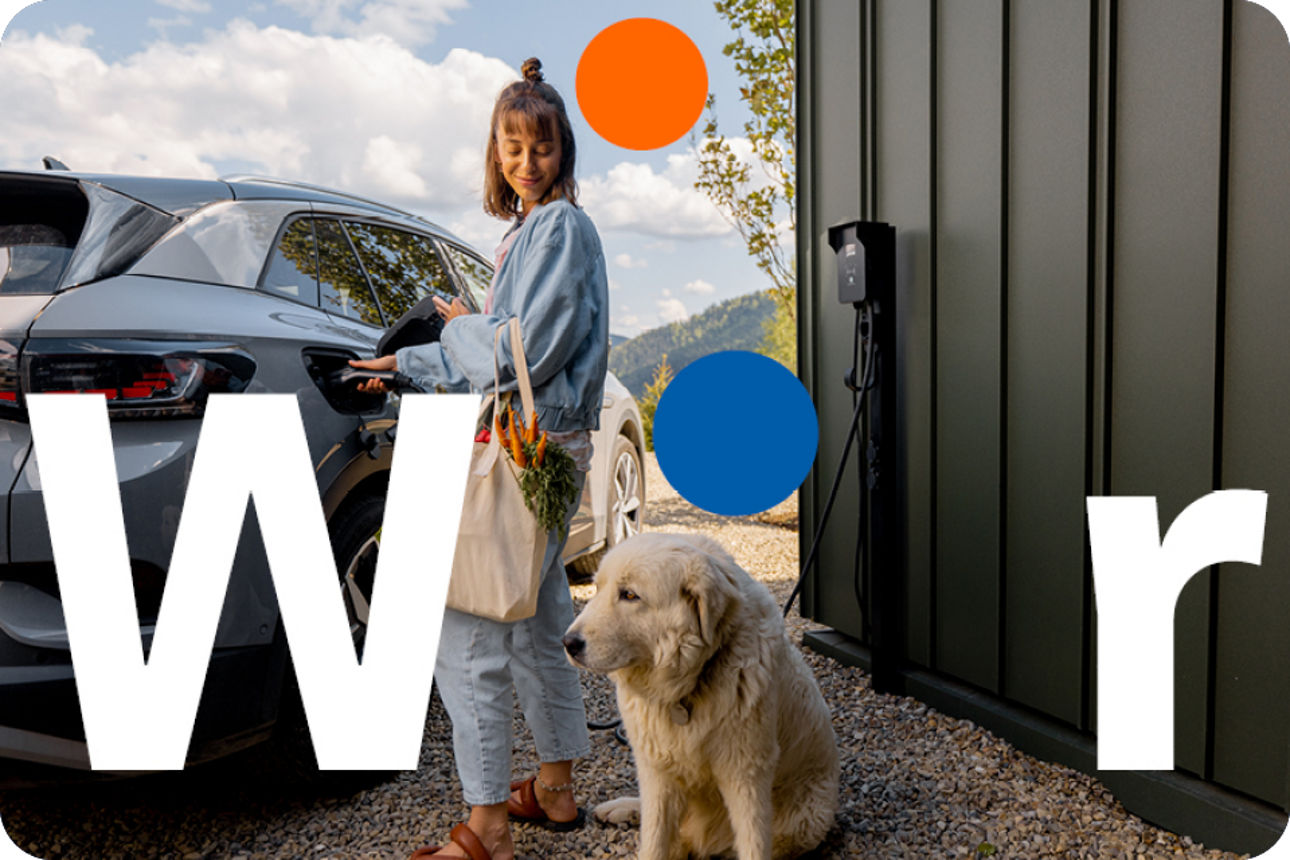 Frau lädt ihr E-Auto. Neben ihr sitzt ein Hund.