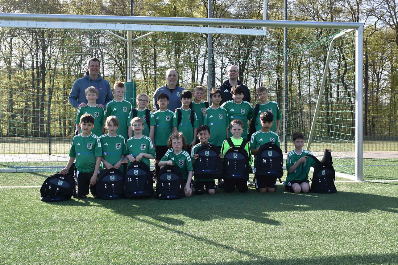 Fußballmannschaft der zweiten E-Jugend des SC Schwarzenbek mit Trainern vor einem Fußballtor