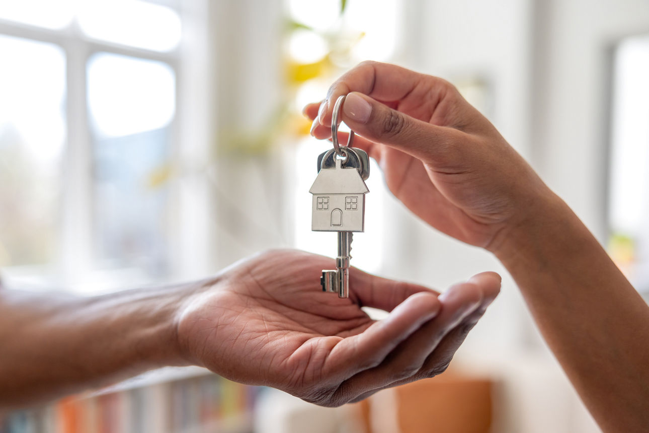 Hände übergeben einen Wohnungsschlüssel.