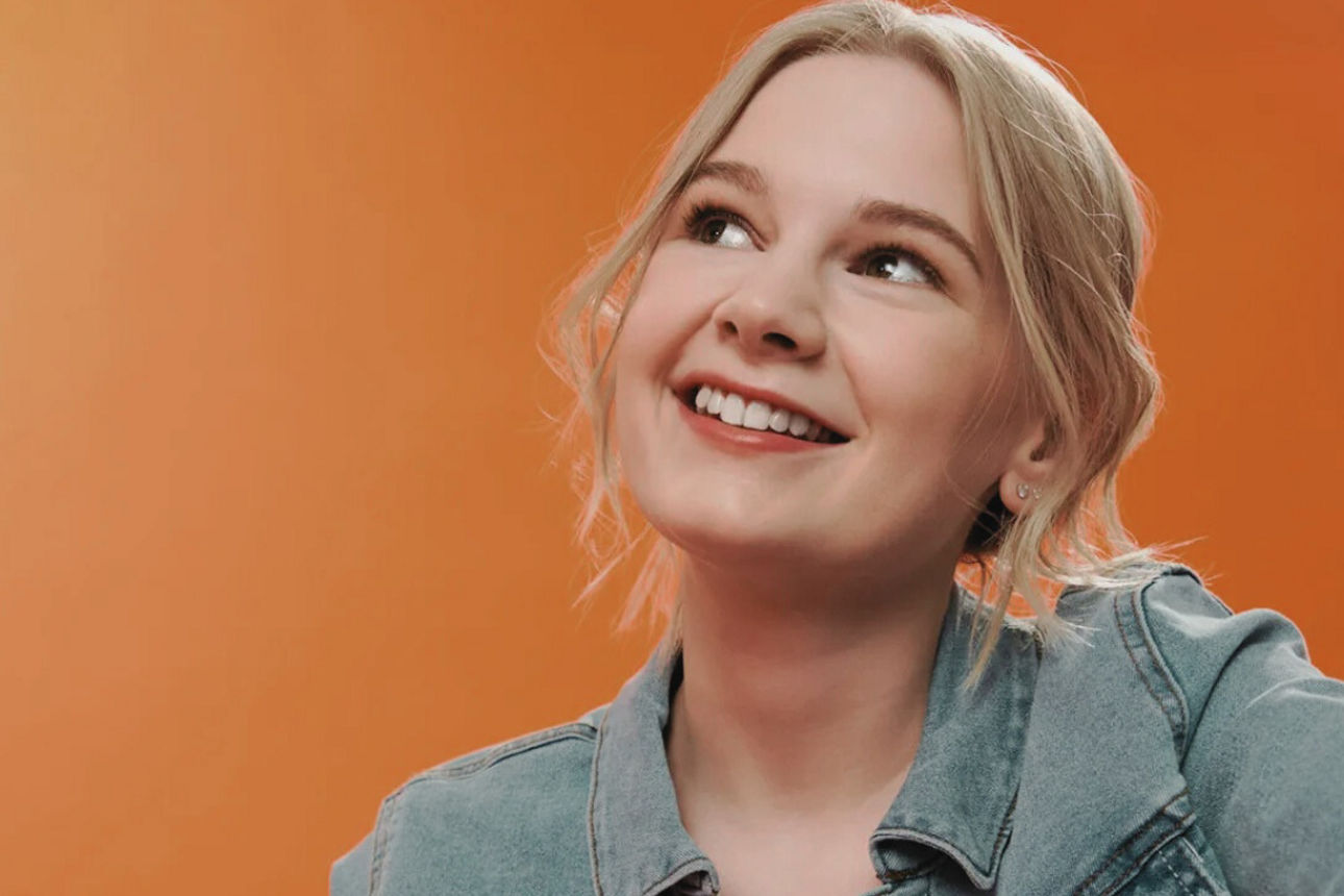 Schülerin mit halblangen blonden Haaren in einer Jeansjacke.