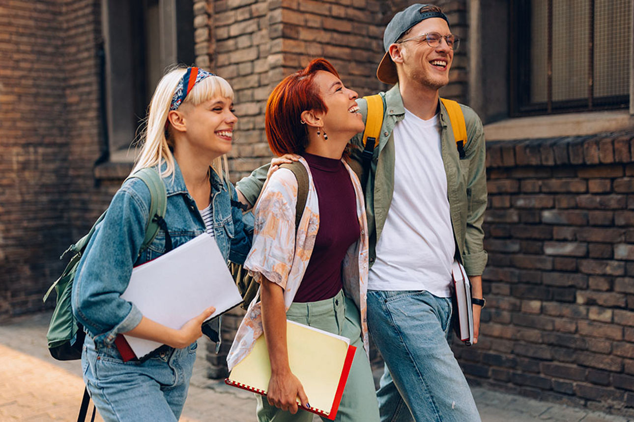 Drei SchülerInnen mit Schulsachen in der Hand