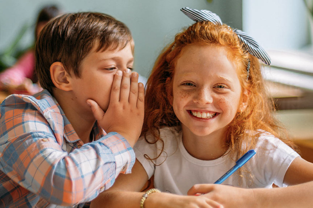 Junge & Mädchen Flüstern in der Schule