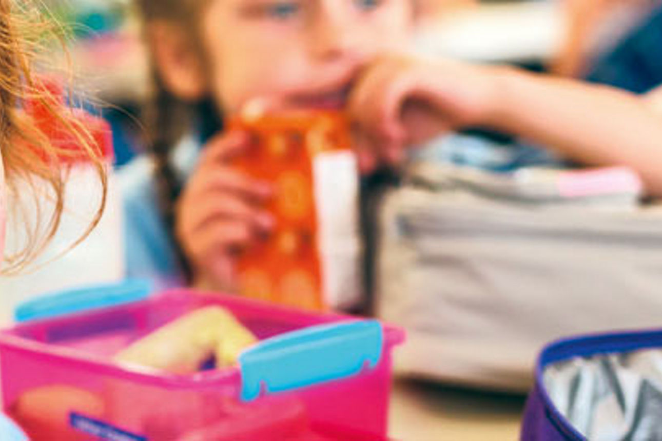 Ein junges Mädchen mit leuchtend rotem Haar und Sommersprossen lächelt