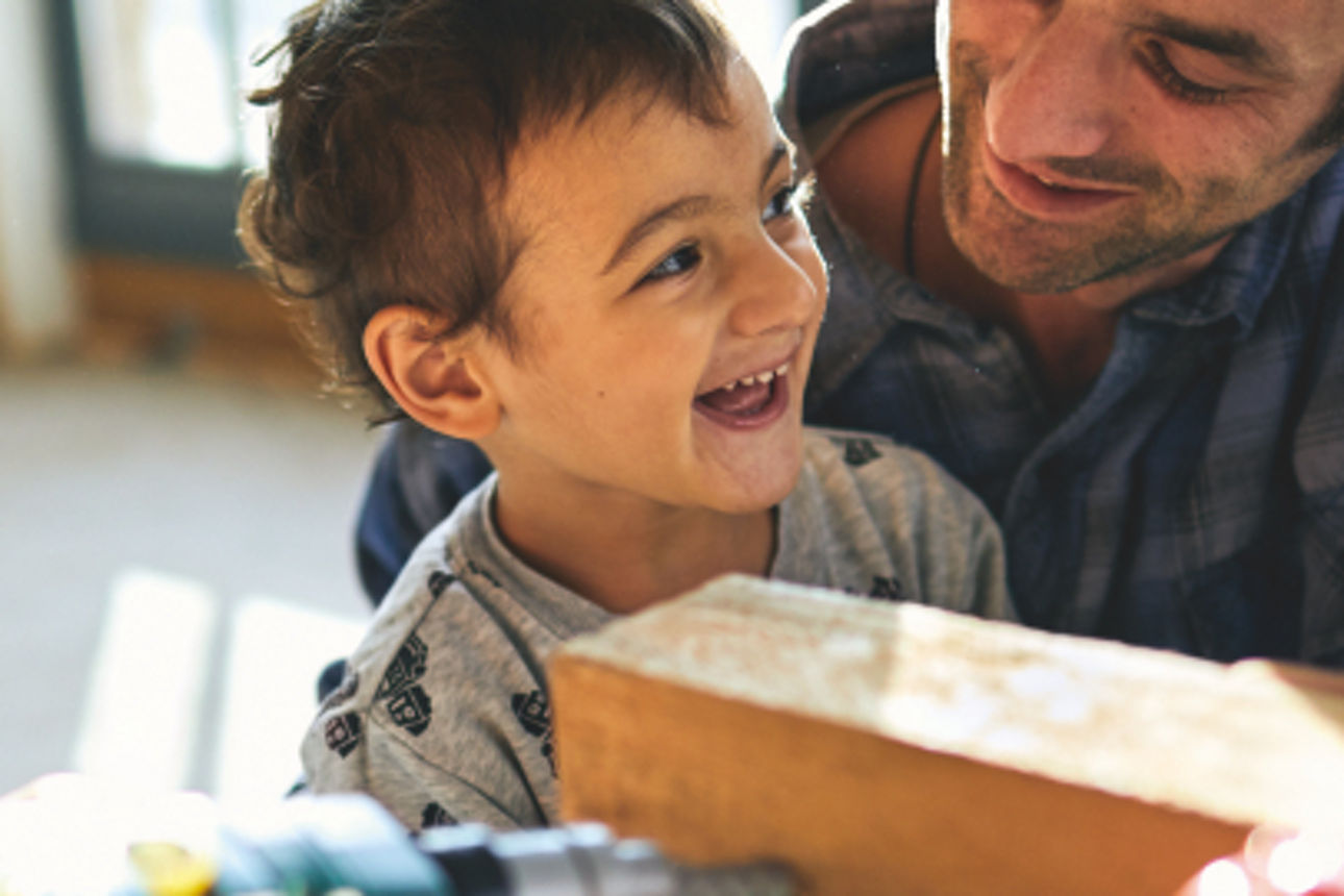 Ein kleiner Junge sitzt auf dem Schoß seines Vaters