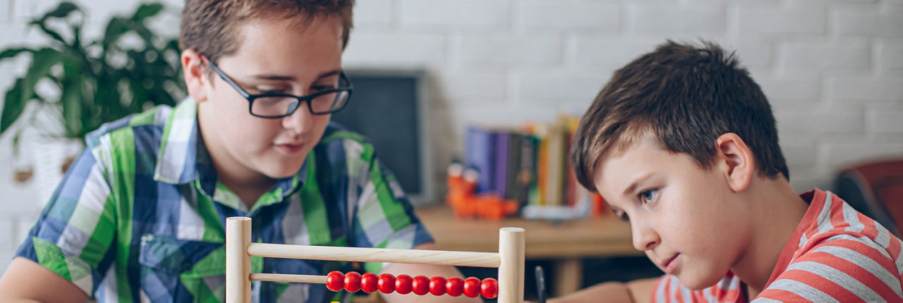 Zwei Brüder machen zusammen ihre Matheaufgaben.