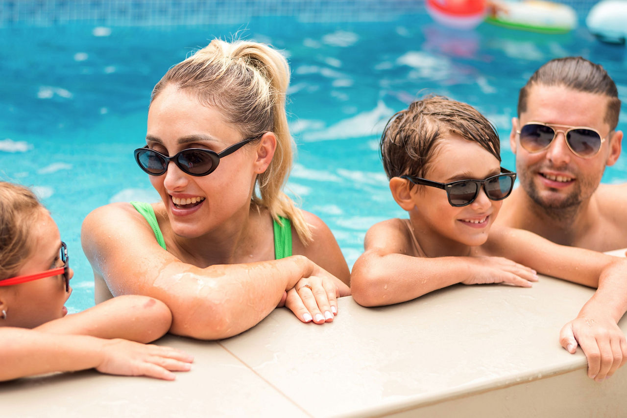 Familie im Pool am Beckenrand