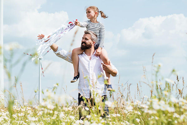 Vater mit Tocher auf den Schultern in der Natur