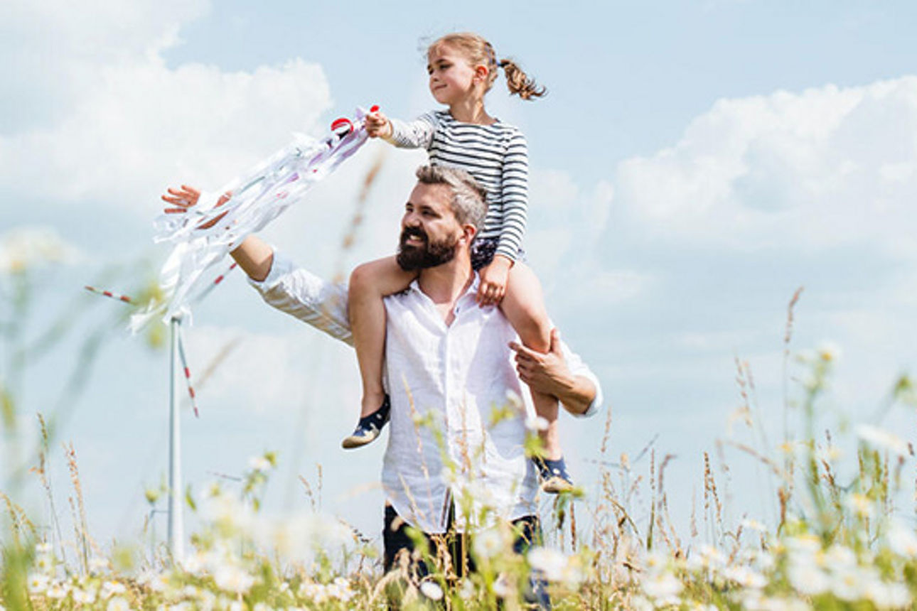 Vater mit Tocher auf den Schultern in der Natur