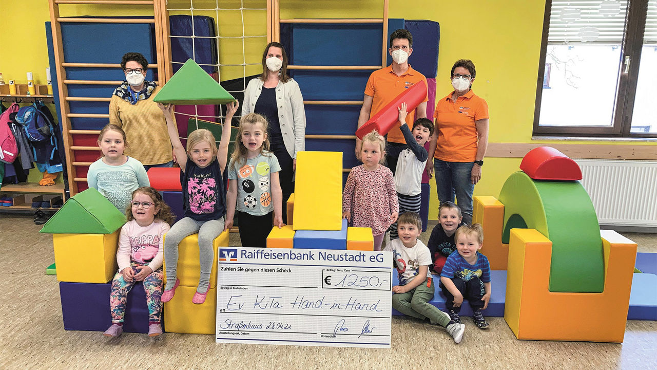 Kinder und Erziehende der Kita Hand in Hand mit Roland Pees und Astrid Kahler sowie den neuen Turnbausteinen in der Turnhalle
