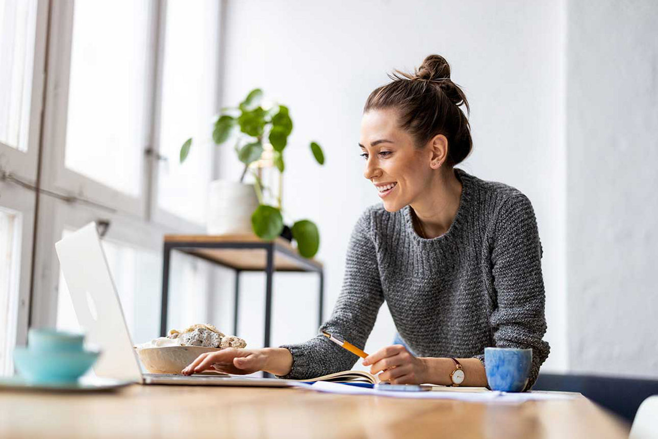 Frau sitzt glücklich vor einen laptop
