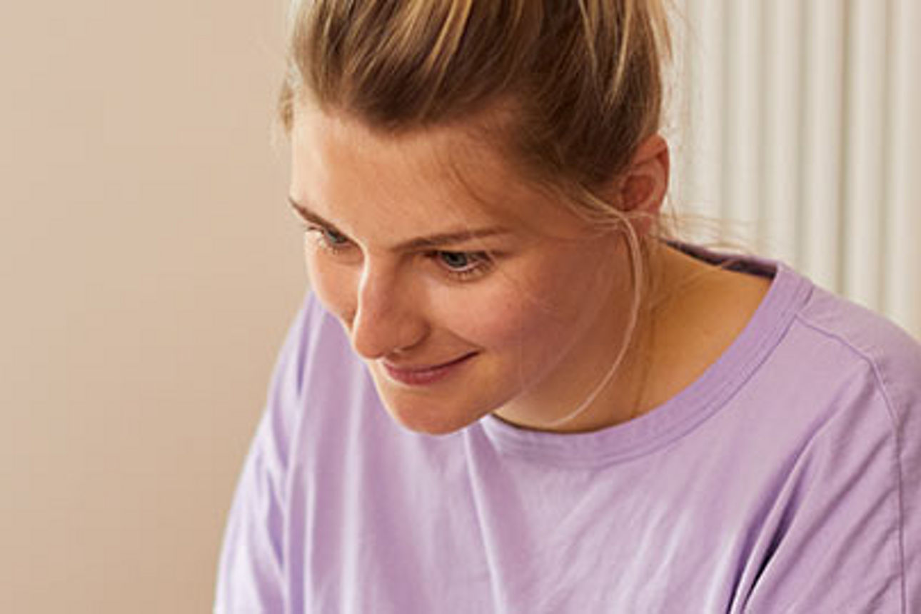 Eine Frau, die konzentriert arbeitet, ihr Gesichtsausdruck nachdenklich.